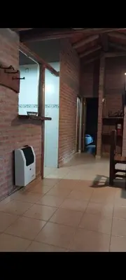 a room with a brick wall and a tv on the wall at Cabañas Rio de Oro in Mina Clavero