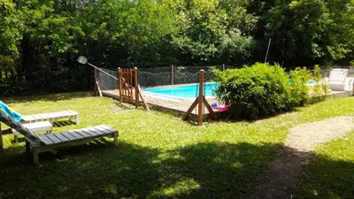 a park with a playground with a pool and two benches at Cabañas Rio de Oro in Mina Clavero
