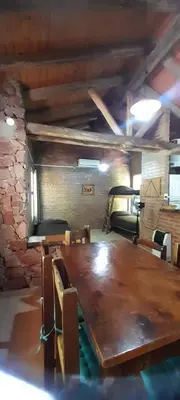 a large wooden table and chairs in a room at Cabañas Rio de Oro in Mina Clavero