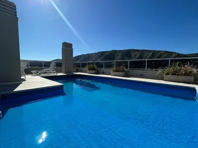 a large blue swimming pool on top of a building at Departamento opera torre 3 in Villa Carlos Paz
