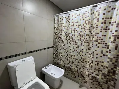 a bathroom with a toilet and a shower curtain at Departamento opera torre 3 in Villa Carlos Paz