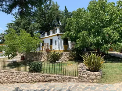 a white house with a fence in front of it at Cabañas Cerro Colonial in Trapiche
