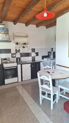 a kitchen with a table and chairs in it at Cabañas Cerro Colonial in Trapiche