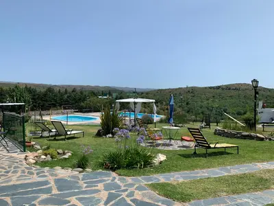 a yard with chairs and a pool and a table and chairs at Cabañas Cerro Colonial in Trapiche