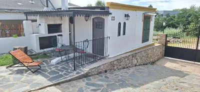 a house with a patio with a table and a chair at Cabañas Cerro Colonial in Trapiche