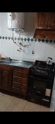 a kitchen with a stove and a counter top at Cabañas Rio de Oro in Mina Clavero