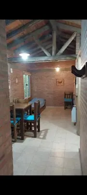 a room with a table and chairs in a room at Cabañas Rio de Oro in Mina Clavero