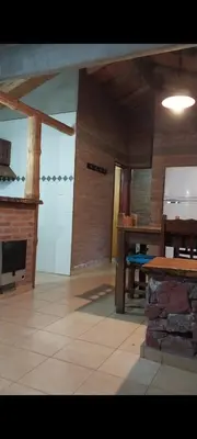 a living room with a table and a fireplace at Cabañas Rio de Oro in Mina Clavero