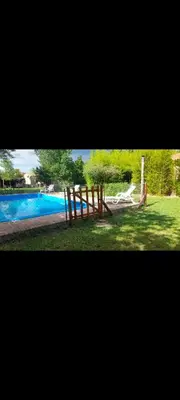 a playground in front of a swimming pool at Cabañas Rio de Oro in Mina Clavero