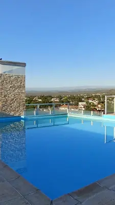 a large blue swimming pool on top of a building at Dept with pool and view in Villa Carlos Paz