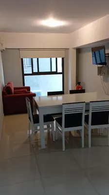 a dining room with a white table and chairs at Dept with pool and view in Villa Carlos Paz