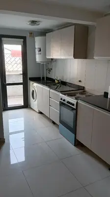a kitchen with a stove and a sink and a dishwasher at Dept with pool and view in Villa Carlos Paz