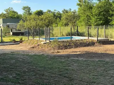 a swimming pool in a yard with a fence at Dos Eucaliptus in Villa Rumipal