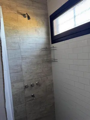 a bathroom with a shower with a glass door at Dos Eucaliptus in Villa Rumipal