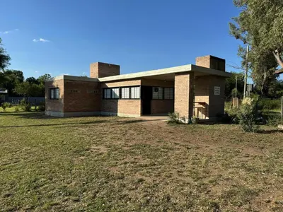 a brick house with a large yard in front of it at Dos Eucaliptus in Villa Rumipal