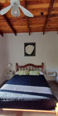 a bedroom with a bed with a ceiling fan at Cabañas Casa Clara in Santa Rosa de Calamuchita