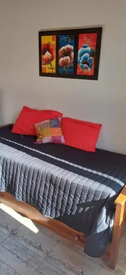 a bedroom with a bed with a blue comforter at Cabañas Casa Clara in Santa Rosa de Calamuchita
