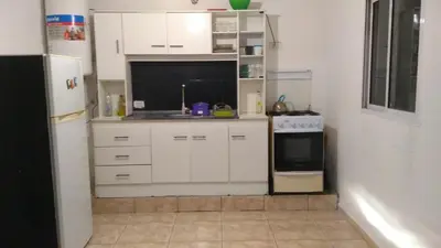 a small kitchen with white cabinets and a refrigerator at Casa jazmines in Villa Santa Cruz del Lago