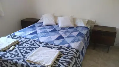 a blue and white bed with two towels on it at Casa jazmines in Villa Santa Cruz del Lago