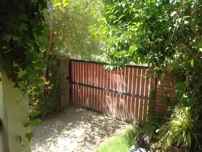 a wooden fence with a gate in a garden at Casa jazmines in Villa Santa Cruz del Lago