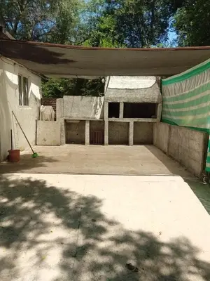 a concrete patio with a building with a canopy at Casa jazmines in Villa Santa Cruz del Lago