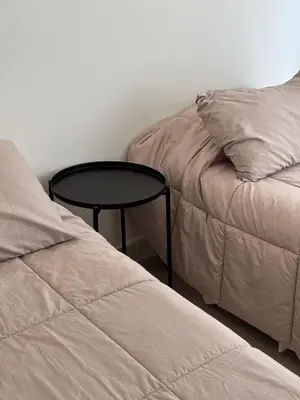 a bed and a table next to a bed and a pillow at Apart France - Charmant Suites in Río Cuarto