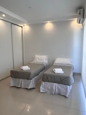 two beds in a room with white walls at Apart France - Charmant Suites in Río Cuarto