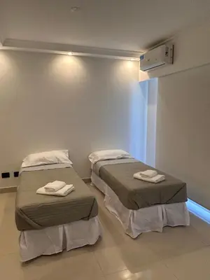two beds in a hospital room with towels on them at Apart France - Charmant Suites in Río Cuarto