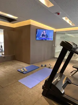 a room with a flat screen tv and a gym at Apart France - Charmant Suites in Río Cuarto