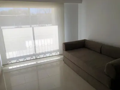 a living room with a couch and a window at Apart France - Charmant Suites in Río Cuarto