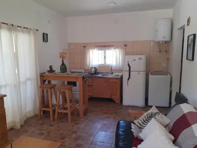 a kitchen with a refrigerator and a table with chairs at Casa Emilia Tanti in Tanti