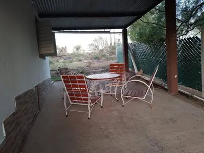 a group of chairs and a table on a patio at El Descanso cabaña in Cavalango
