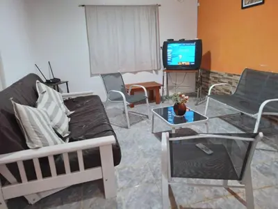 a living room with a couch and a tv at El Descanso cabaña in Cavalango