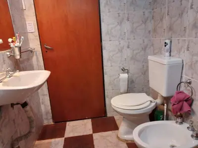 a bathroom with a white toilet and a sink at El Descanso cabaña in Cavalango