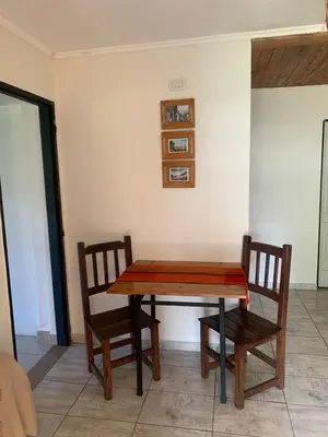 a wooden table and two chairs in a room at El despertar Hospedaje in San Francisco del Monte de Oro