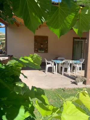 a patio with a table and chairs in front of a house at El despertar Hospedaje in San Francisco del Monte de Oro