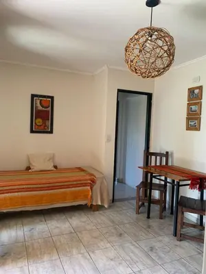 a bedroom with a bed and a table and a chandelier at El despertar Hospedaje in San Francisco del Monte de Oro