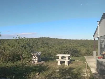 a picnic table in the grass with a view of a hill at Tinkunaco Alta Gracia in Alta Gracia