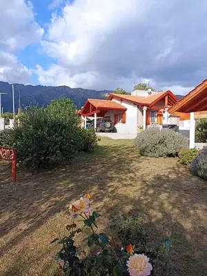 a house with a yard with flowers in front of it at Cabañas Qhawana in Carpintería