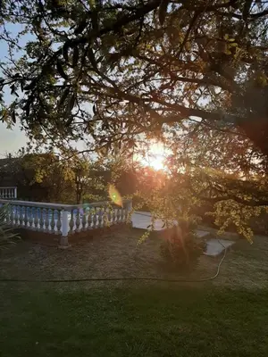 a sun setting behind a fence in a park at Cabañas Qhawana in Carpintería