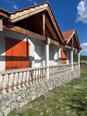 a house with a stone wall at Cabañas Qhawana in Carpintería