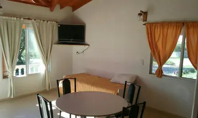 a bedroom with a bed and a table with chairs at Cabañas Qhawana in Carpintería