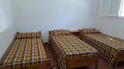 a group of three beds in a room at Casa en Santa Rosa de Calamuchita in Santa Rosa de Calamuchita