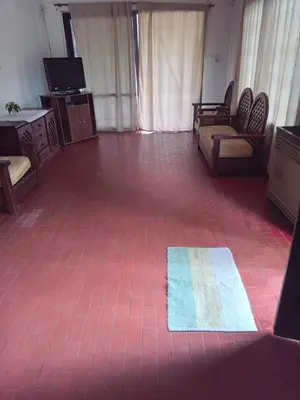 a room with a tiled floor with a couch and a tv at Casa en Santa Rosa de Calamuchita in Santa Rosa de Calamuchita