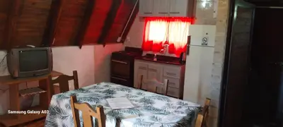 a small kitchen with a table and a television at Cabañas Alpinas M y M in Bialet Massé