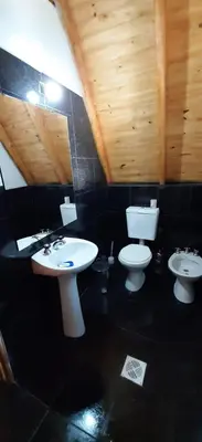 a bathroom with two sinks and a toilet at Cabañas Alpinas M y M in Bialet Massé