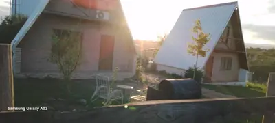 a house with a grill in front of a yard at Cabañas Alpinas M y M in Bialet Massé