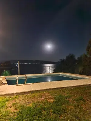 a swimming pool at night with the moon in the sky at Casalago in Villa Carlos Paz
