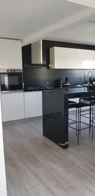a kitchen with a black counter and a table at Casalago in Villa Carlos Paz