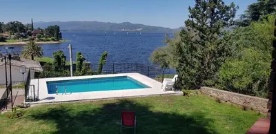 a swimming pool next to a body of water at Casalago in Villa Carlos Paz